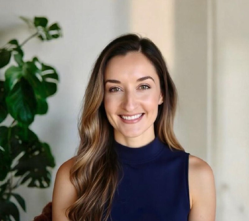 Heley Babrak smiling in a blue top with a plant in the background